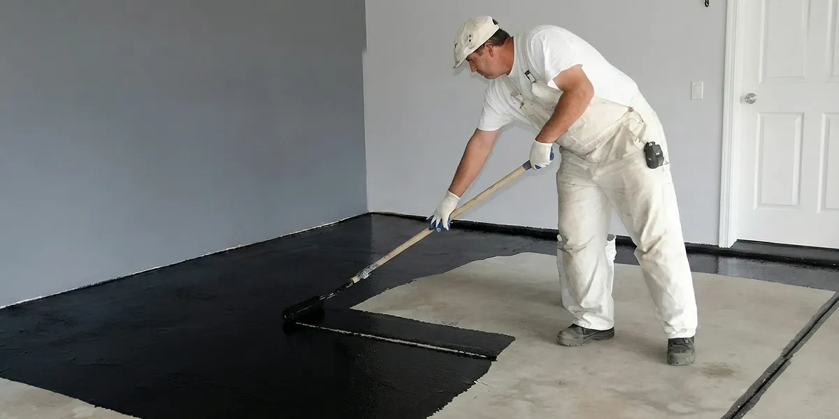 basement waterproofing professional applying waterproof coating to protect a basement floor in Fort Collins, CO